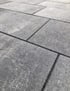 Große, rechteckige Terrassenplatten aus grauem Naturstein mit dunklen Fugen in perspektivischer Ansicht.