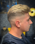 Profilansicht eines Mannes mit blondem Haar, einem mittellangen Fade und einem schlichten T-Shirt.