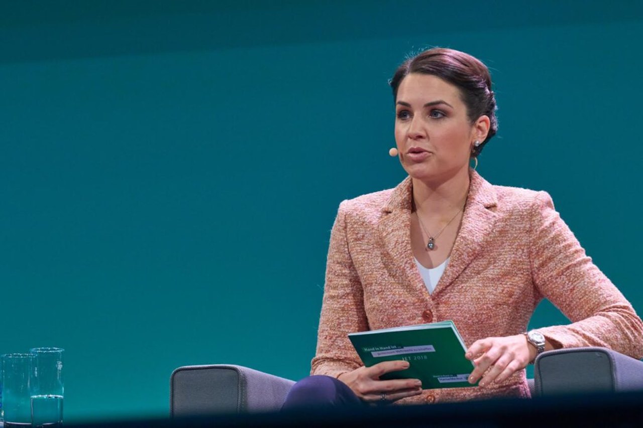 Julia Bauer moderiert auf einer Bühne