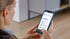 Frau nutzt ein Smartphone mit der Europcar App zur Auswahl von Mietfahrzeugen wie PKW, LKW oder Transportern.