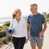 Couple strolls by the sea, thanks to bone on bone joint pain treatment.