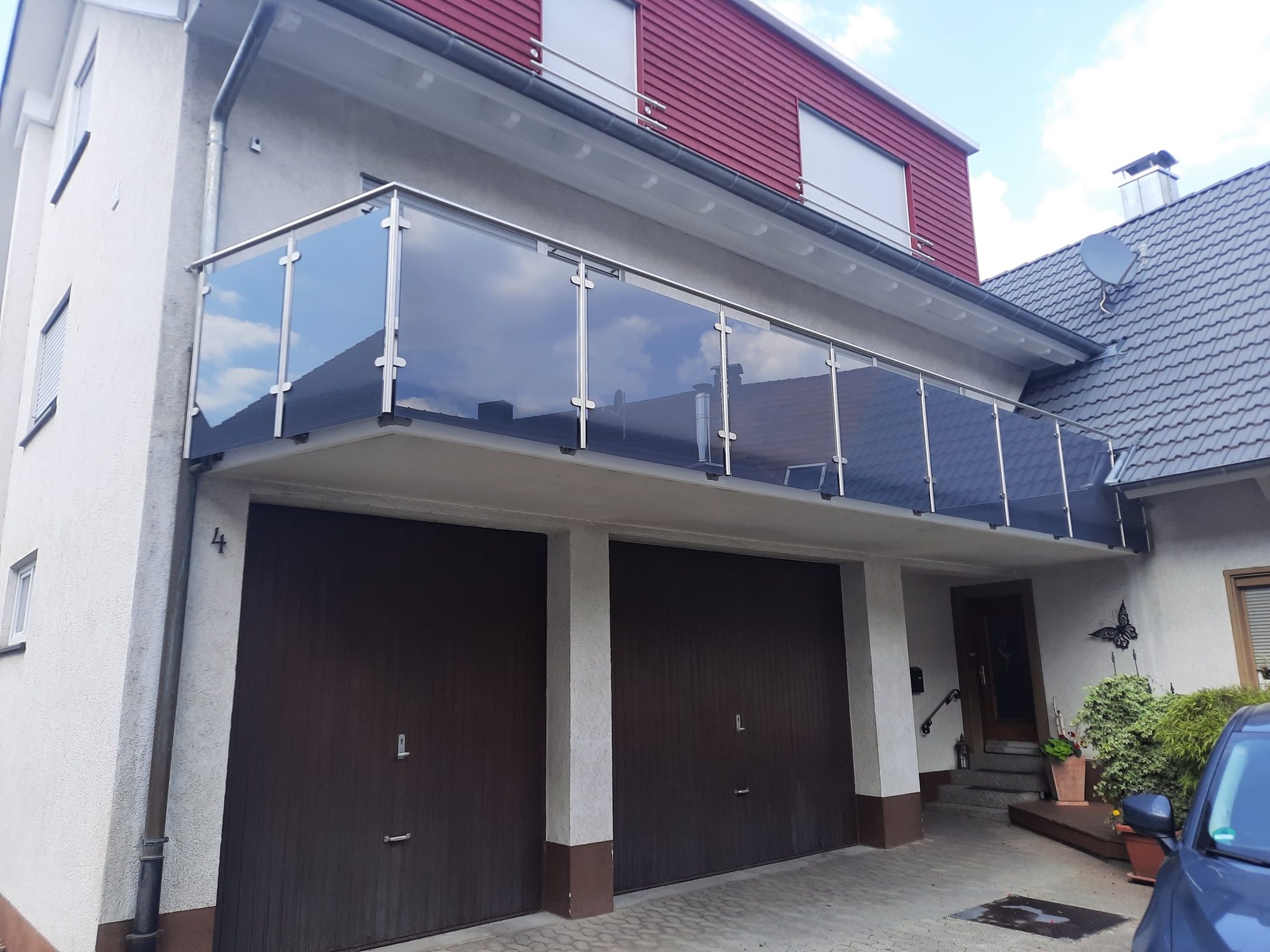 Balkongeländer aus Edelstahl mit Rauchglas an einem Haus mit Doppelgarage