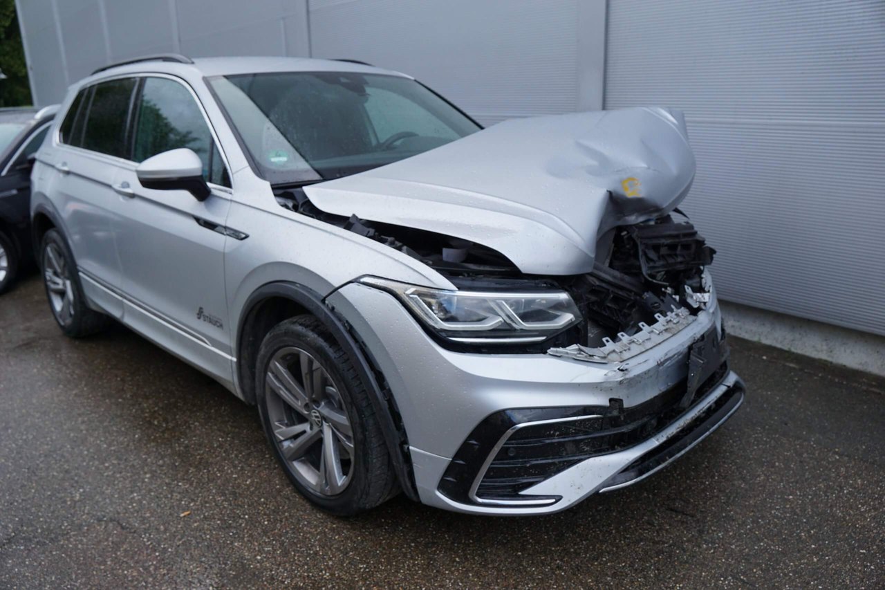 Silberner SUV mit starkem Frontschaden auf nasser Straße