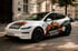 Weißes Tesla Model Y mit Schacht'l Helden Umzugs-Branding und Superhelden-Grafik parkt auf einer gepflasterten Straße.