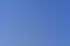 Grüne Drachenstatue mit ausgebreiteten Flügeln und offenem Maul vor blauem Himmel.