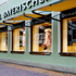Schaufenster eines Trachtengeschäfts mit Dirndln auf Schaufensterpuppen und gelben Markisen.