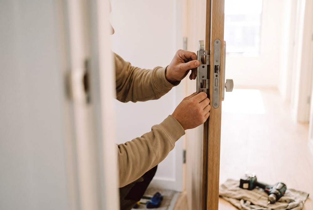 Sicherheitsschließblech und Schutzbeschlag werden an einer Wohnungstür montiert