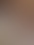 Eine Frau mit Brille und Kopfhörern blickt direkt in die Kamera, im Hintergrund ein Monitor und ein buntes Bild.