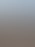 Metallrahmen für Photovoltaikanlagen auf einem mit Kies bedeckten Flachdach vor städtischer Kulisse.