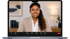 Laptop mit lächelnder Frau im Videokonferenz-Bildschirm, im Hintergrund ein Bücherregal und eine Lampe.