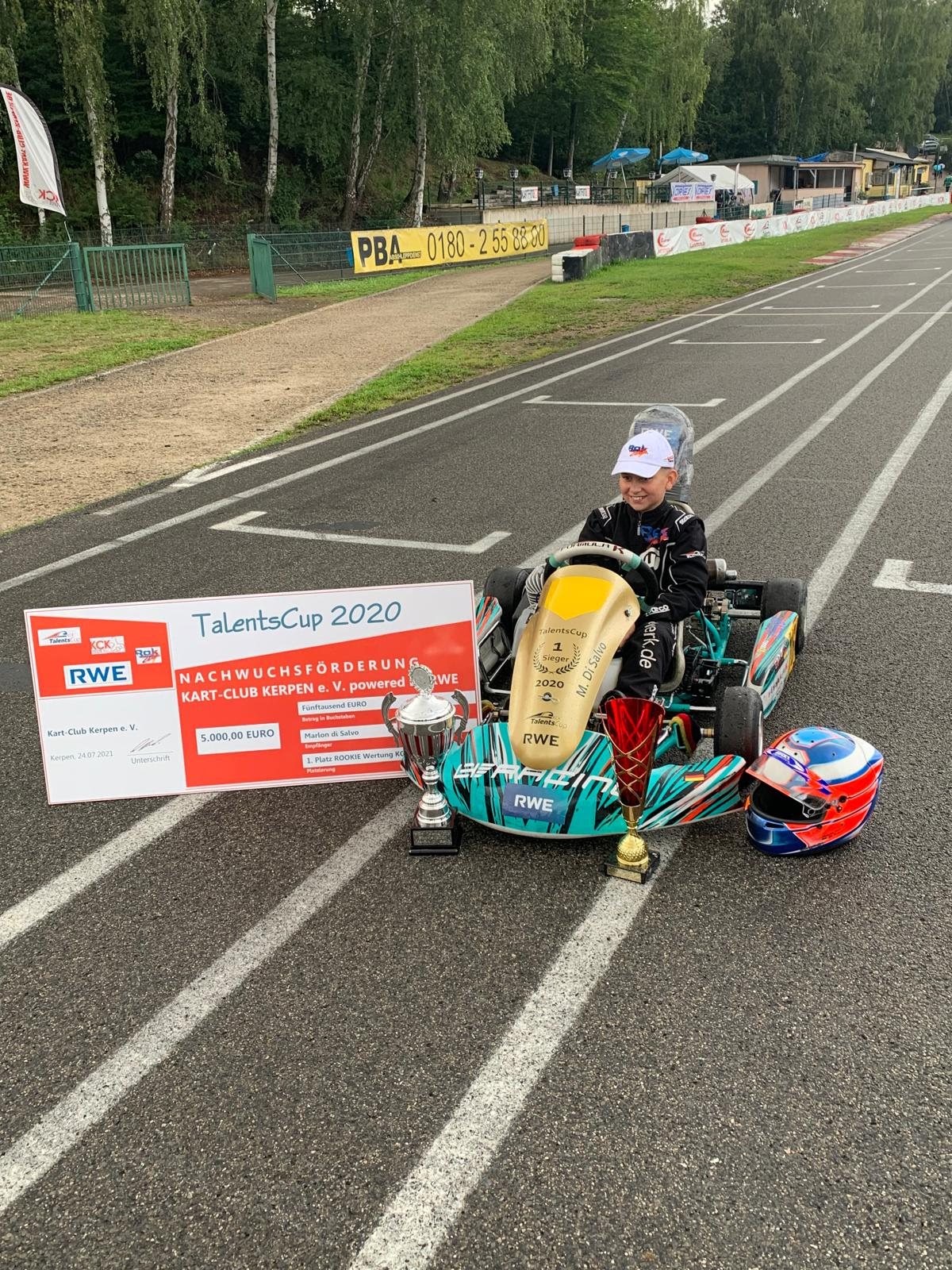 Marlon im Kart neben dem Scheck und den Pokalen vom Talents Cup 2020