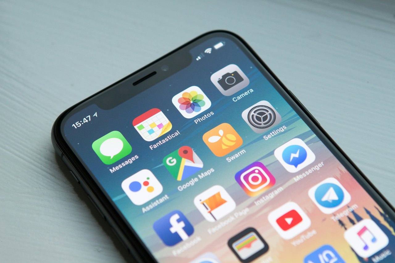 Nahaufnahme eines iPhone-Displays mit verschiedenen App-Icons wie Google Maps, Instagram, Facebook und YouTube.