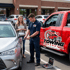 Towing Sandy car lockout service helping a driver regain access to a locked vehicle using professional unlocking tools in a parking lot.