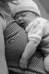 Baby schläft auf der Brust der Mutter bei liebevoller Stillberatung durch erfahrene Hebamme – inniger Moment im Stillkurs.