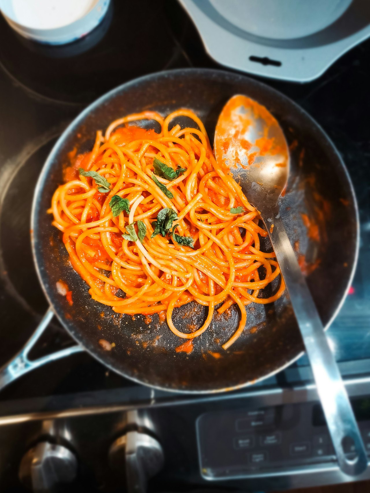 Pasta in Tomatensauce mit frischem Basilikum in der Pfanne