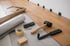 Werkzeuge und Material zum Verlegen von Laminatboden, darunter Hammer, Klebeband und Abstandhalter.