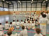 Keigo Shimizu Sensei spricht vor einer Gruppe von Kindern und Erwachsenen in einer Sporthalle.