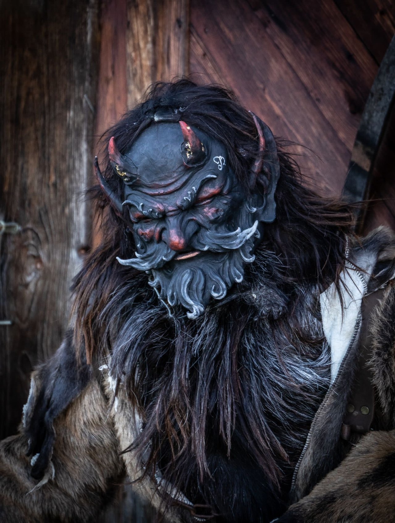 Krampus mit geschnitzter Maske, Hörnern und Fellgewand
