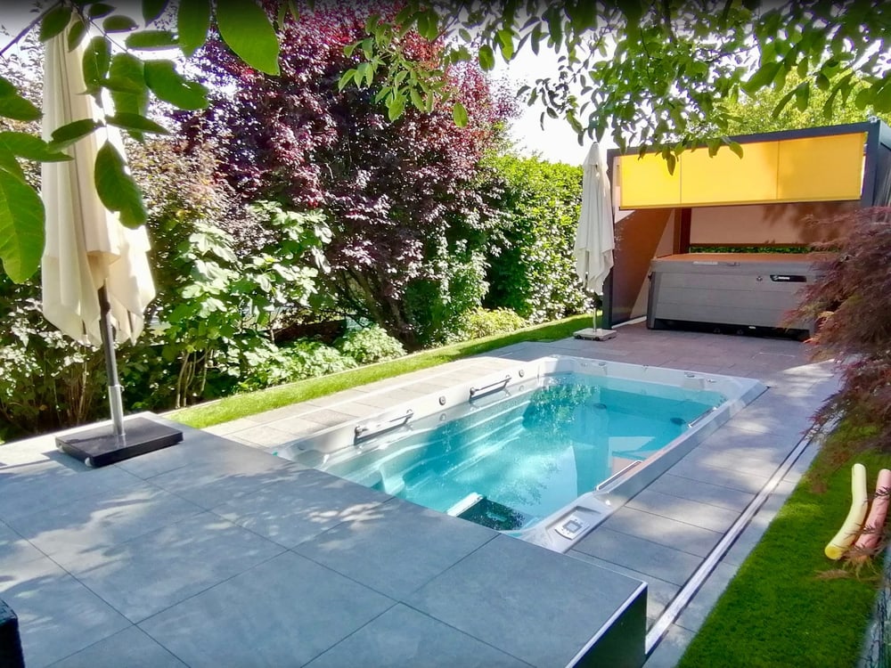 Swim Spa mit geöffneter Abdeckung und Bepflanzung