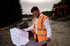 Christian Roßmann überprüft Baupläne auf einer Baustelle in orangener Sicherheitsweste.