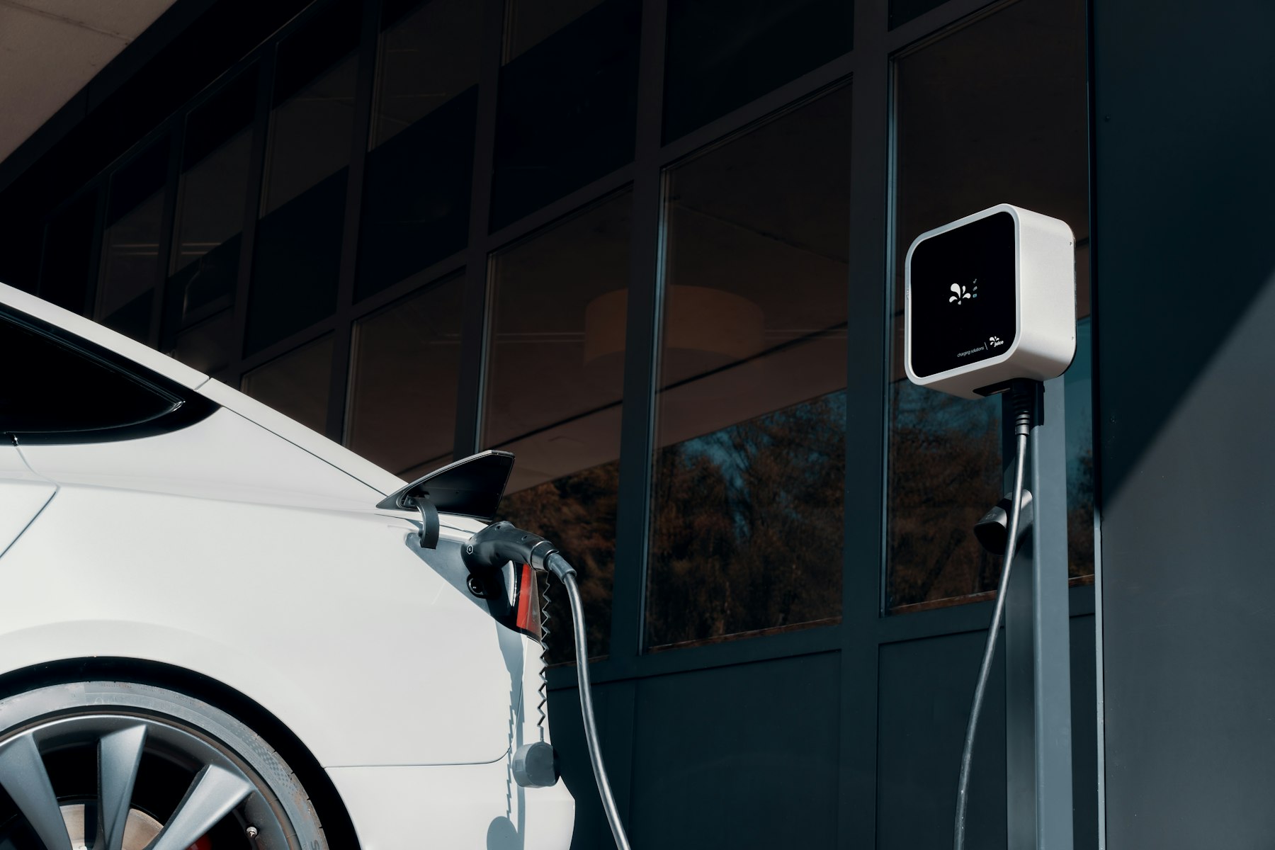 Driver plugging a charging cable into an electric vehicle at home in Yorba Linda