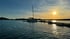 Sonnenuntergang über dem Meer mit einer Yacht und einem Steg, im Hintergrund bewaldete Inseln in Drage Kroatien.
