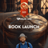 A man in a hat smiles below "BOOK LAUNCH" text, a decorative box, and a "Legend Haven" banner.