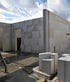 Exterior walls of a building under construction made of large white autoclaved aerated concrete blocks under a cloudy sky.