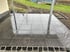 Neu verlegte, glänzende Granit-Terrassenplatten mit dunkler Kopfsteinpflaster-Einfassung im Garten.