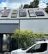 Modernes Haus mit Solarmodulen auf dem Dach und einem weißen AKD Gebäudereinigung Lieferwagen davor.