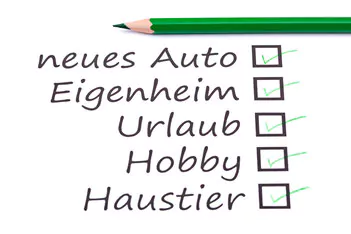 Checkliste mit Anschaffungswünschen wie neues Auto, Eigenheim, Urlaub, Hobby und Haustier, daneben ein grüner Buntstift