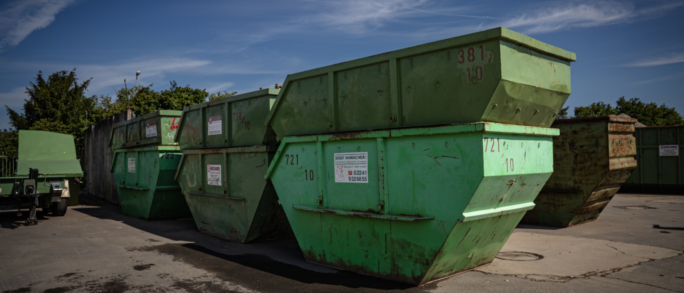 Reihe grüner Absetzcontainer von Bücher Containerdienst auf dem Betriebshof