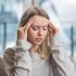 Woman holding head, appearing to have headache









