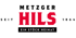 Logo der Metzgerei Hils mit rotem "HILS", schwarzem "METZGER", "SEIT 1864" und "EIN STÜCK HEIMAT" auf grünem Grund.