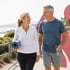 An active couple walks by the sea thanks to nerve pain treatments.
