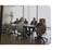 Eine Gruppe von Geschäftsleuten sitzt bei einer Besprechung an einem großen Konferenztisch in einem hellen Büro - Software für Stabsarbeit - Notfall- und Krisenmanager (NKM®).