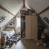 Schlafzimmer mit Dachschräge, in dem ein freistehender Standardkleiderschrank sichtbare Lücken hinterlässt
