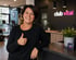 Frau mit kurzem Haar lächelt, gibt Daumen hoch an der Rezeption von "club vital".