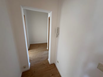 Leerer kleiner Raum mit Laminatboden und offener Tür