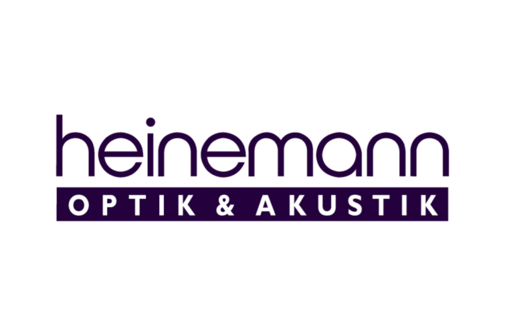 Heinemann Optik & Akustik Logo: "heinemann" in lila, darunter "OPTIK & AKUSTIK" in weiß auf lila Balken.