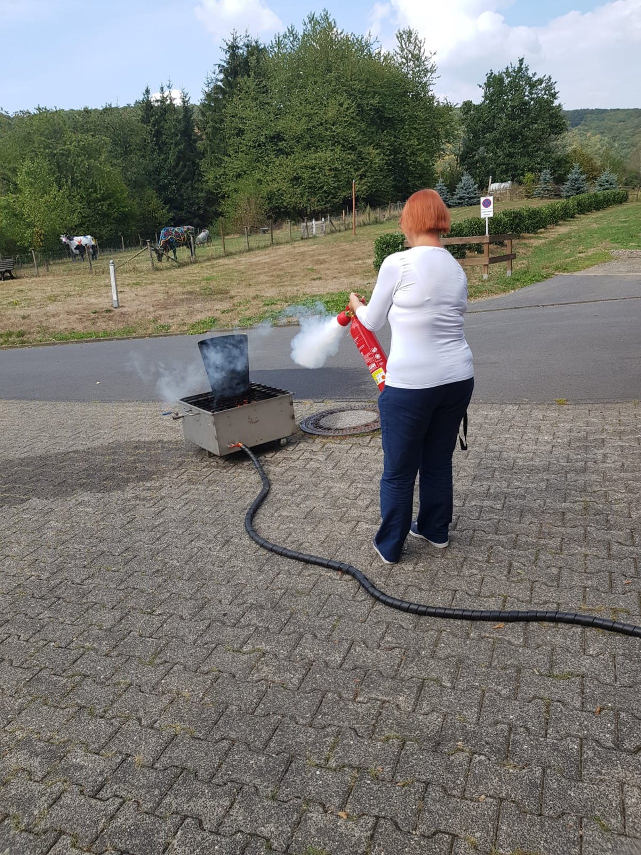 Teilnehmerin &uuml;bt erneut den Umgang mit dem Feuerl&ouml;scher w&auml;hrend einer Auffrischungsschulung