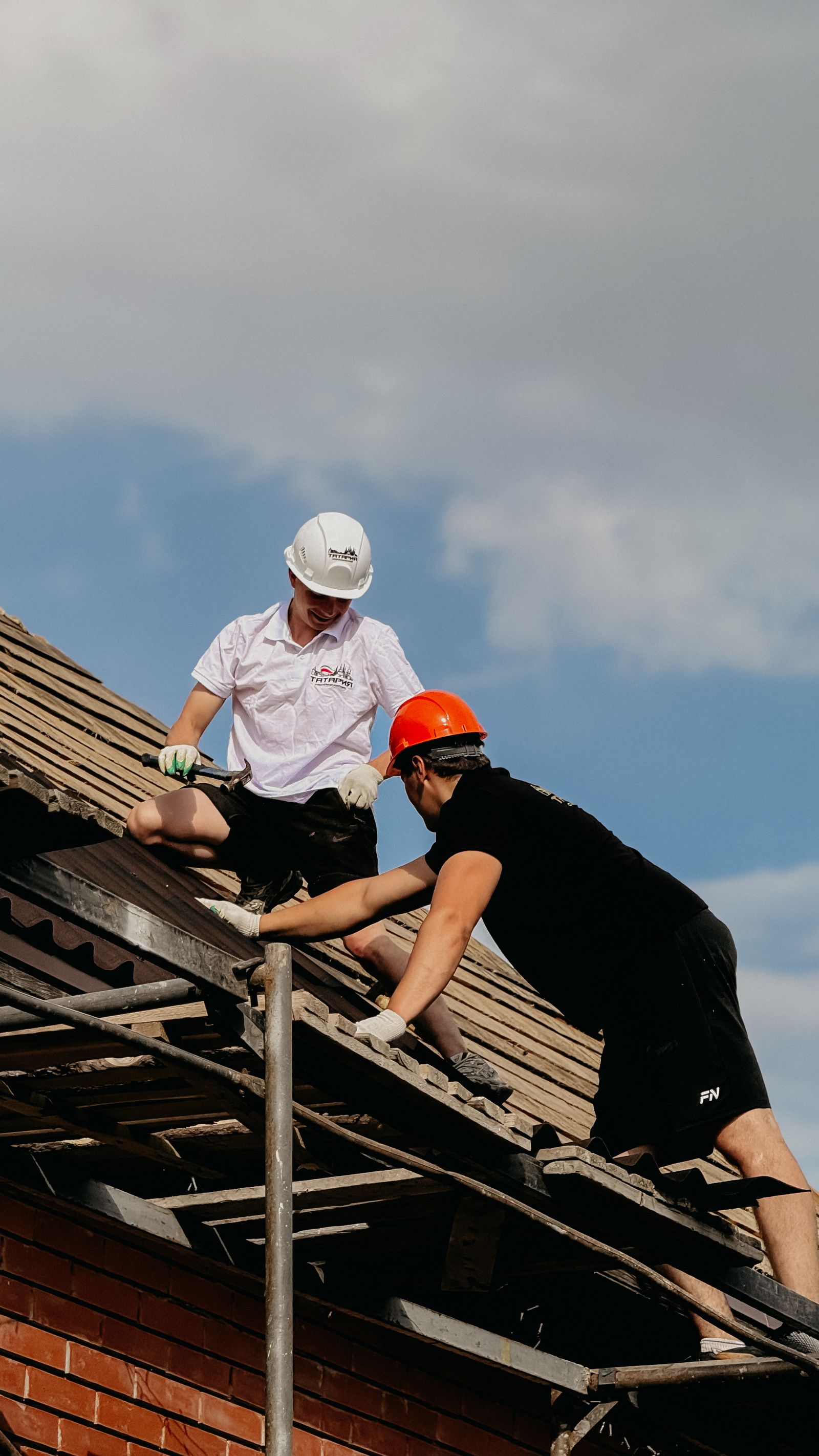 Two roofers working a repair together on a residential roof