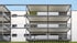 Moderne weiße Hausfassade mit mehreren Balkonen und anthrazitfarbenen Metallgeländern.
