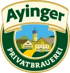 Ayinger Privatbrauerei Logo: Dorfansicht mit Kirche und Häusern, darüber "Ayinger" auf einem Banner.
