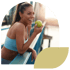 A happy young woman in activewear smiling and eating an apple.