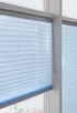 Helles Plissee vor einem Wohnzimmerfenster