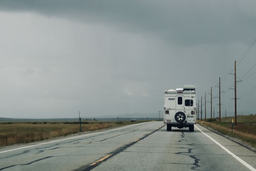 Motorhome alone on an open highway under storm clouds, the situation before an RV breakdown near Corona, CA