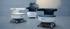 Drei moderne, ergonomische Next Generation One Bürostühle in Weiß und Schwarz mit integriertem Logo vor grauem Hintergrund.