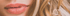 Nahaufnahme von Lippen mit pinkfarbenem Lippenstift und blonden, lockigen Haaren.