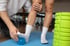 Ein Therapeut hilft einem Patienten beim Training mit einem Massageball für den Fuß und einer Schaumstoffrolle.